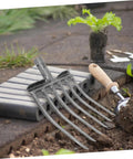 Heavy Duty Steel Garden Fork For Soil Loosening And Planting Area Prep, Rugged Multi Purpose Farm Tool on garden bed