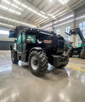 Heavy Duty Four Wheel Drive Telehandler Forklift With Extended Reach Boom For Smooth Material Moves And Pro Grade Lifting Projects Built Tough With Zero Sweat For Busy Job Sites, side view in a warehouse.