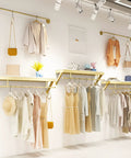Top Shelf Wall Mounted Clothing Rack System Kit Crafted from Rock Solid Wrought Iron Pipes and Rugged Pine Boards for Boutique or Main Street Closets That Can Take Some Serious Wear and Tear featuring stylish garments and shelves.