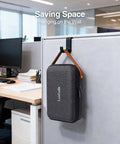 The Ultimate Go To Tech Organizer Travel Case For Portable Electronics And Daily Cord Management Featuring A Smooth Leather Handle Compact Fit hanging on an office wall.