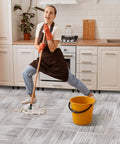 Woman mopping No Fuss Peel And Stick Wood Grain Vinyl Floor Tiles 12 By 12 Inch 48 Pack Waterproof Self Adhesive Flooring in kitchen.