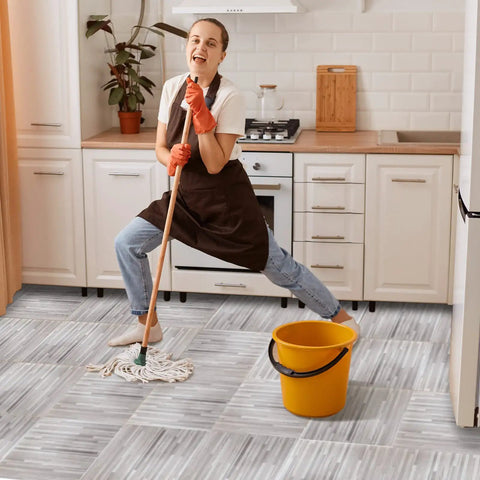 Woman mopping No Fuss Peel And Stick Wood Grain Vinyl Floor Tiles 12 By 12 Inch 48 Pack Waterproof Self Adhesive Flooring in kitchen.