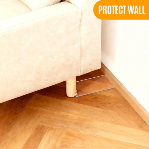 Clear Acrylic Couch Wall Spacer And Bed Blocker Stops Furniture Scrapes Keeps Heaters Cool Preserves Outlet Access Built Tough No Sweat Setup Invisible Wall Guard Anti Scratch Two Pack under couch leg on wooden floor.