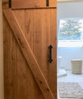 Wooden barn door with 9 Inch Sliding Barn Door Handles Two Pack Black Powder Coated Iron Pull Handles For Gates Garage Outdoor Fence And Interior Closet Doors With No Slip Grip And Rust Proof Finish.