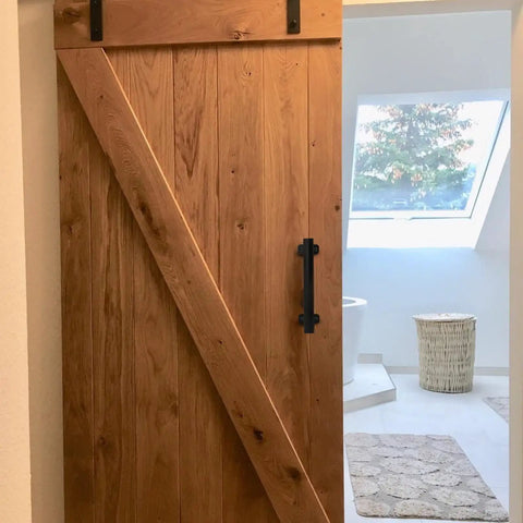 Wooden barn door with 9 Inch Sliding Barn Door Handles Two Pack Black Powder Coated Iron Pull Handles For Gates Garage Outdoor Fence And Interior Closet Doors With No Slip Grip And Rust Proof Finish.