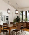 Cozy Farmhouse Style Plug In Pendant Light With Rustic Wood And Glass Cylinder illuminating kitchen island, industrial bronze finish.