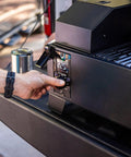 Person adjusting temperature on Table Top Wood Pellet Grill With Flame Broiler For Direct Searing Up To 1000°F, 7 Lb Hopper