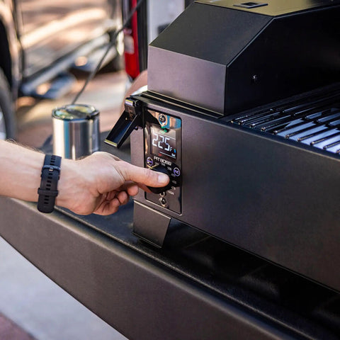Person adjusting temperature on Table Top Wood Pellet Grill With Flame Broiler For Direct Searing Up To 1000°F, 7 Lb Hopper