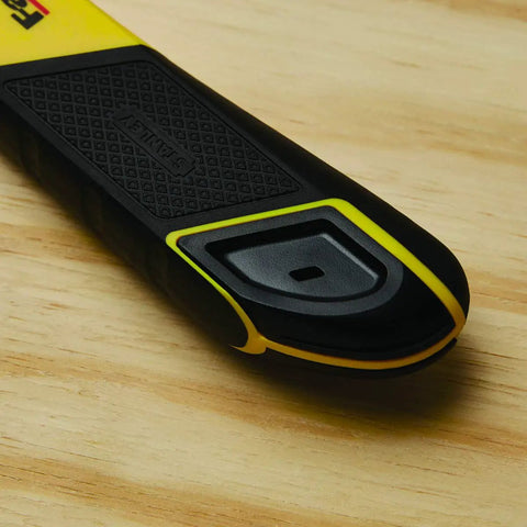 Close-up of black and yellow FatMax Snap Off Knife durable utility knife with ergonomic grip on wood surface.