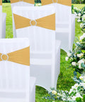 Gold spandex chair sash with rhinestone ring slider on a white banquet chair outdoors