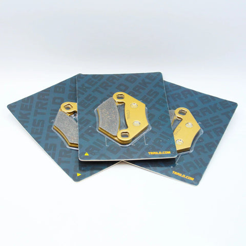 Three ceramic brake pad assemblies for Polaris Sportsman 850/570/550/450 (2009–2026), front & rear, on Traild cards.
