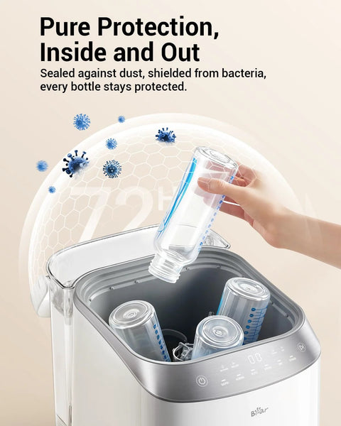 Front view of Bear Bottle Washer Pro; white/silver baby bottle sterilizer and dryer with bottle being inserted.