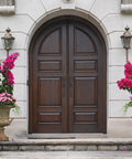 Double wooden arched doors with decorative columns, featuring Matte Black Double Door Handle Set With Heavy Duty Zinc Alloy Construction.