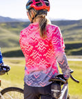 Back view of cyclist wearing Vista Long Sleeve Women Cycling Jersey For Mountain Biking And Gravel Riding, Large, Red Rocks color