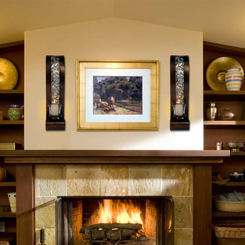Antique bronze wall sconces featuring openwork glass shade tealight holders mounted beside a framed painting for cozy ambiance.