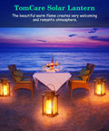 Lit Outdoor Solar Lantern With Realistic Flickering Flame, Metal Hanging Lanterns on a beach with a dining setup at sunset.