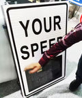 Person pointing to Solar Powered Radar Speed Sign With Real Time Speed Display For Highways And Speed Limited Roads, Wireless Setup