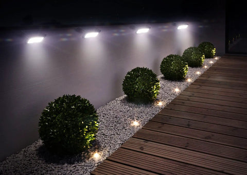 1100 Lumen Solar Outdoor LED Flood Light With PIR Motion Sensor Black Five In One Wall Mount illuminating garden path at night