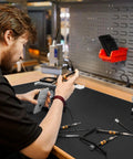Man working at a bench with Heavy Duty Tool Box Liner 16 Inch By 16 Foot Roll 3mm Thick Non Slip Grid Line Drawer Mat in use.