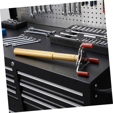 Slick Aluminum Smoke Sensor Removal Tool For Ceilings on workbench with metal tools in background, showcasing its grip and design.