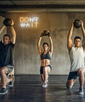 Don't Wait LED Neon Sign Wall Decor Do It Neon Light USB Powered Adjustable Brightness in a gym setting with people exercising