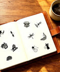 Zero Fuss Self Inking Craft Stamp Showing A Vintage Blank Clock Dial Design For Scrapbooking And Journal Projects That Amps Up Your Creative Flow With Super Clean Prints Every Time on an open notebook.