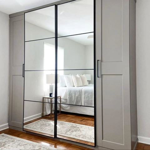 Bedroom wardrobe with mirrored doors reflecting a bed and side table, showcasing All In One Refinishing Paint For Furniture And Cabinets No Stripping No Sanding No Priming Needed Pebble Color Quart Easy To Apply With A Pro Finish For DIY Home Makeovers.