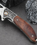 Dope Damascus Steel Folding Pocket Knife with 3.46 Inch blade and rosewood handle on rock surface