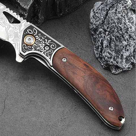 Dope Damascus Steel Folding Pocket Knife with 3.46 Inch blade and rosewood handle on rock surface