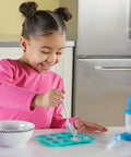 Child using Yumology Science Sweets Lab Kit For Kids, A Fun Candy Science Set With Candy Experiments, in a kitchen setting.