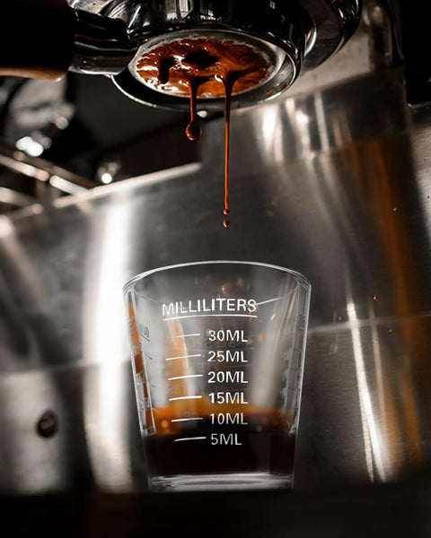 Two Pack Espresso Shot Glass Measuring Cup Set With Red Scale, Heavy Glass Barware with espresso drip under machine.