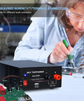 Person working with 13.8V 30A DC Power Supply For Ham Radios And Bench Projects, compact regulated benchtop converter visible.