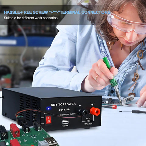 Person working with 13.8V 30A DC Power Supply For Ham Radios And Bench Projects, compact regulated benchtop converter visible.