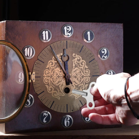 Person using Gearhead Favorite Wrench Clock Key For Winding Mechanical Clocks, 4.4mm Hole, 52mm Long Steel Key in wooden clock