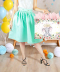 Woman holding a 13 Inch Large Baby Shower Gift Bag For Girls With Pink Floral Elephant Design And Durable Handles Includes Tissue Paper Pack And Greeting Card No Fuss Quick Gift Wrapping For Baby Showers Or Birthday Parties, surrounded by decorative balloons.