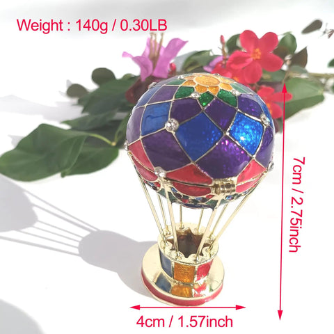 Totally Vintage Enamel Hot Air Balloon Jewelry Box With Rhinestones next to red flowers, eco-friendly decorative trinket storage.