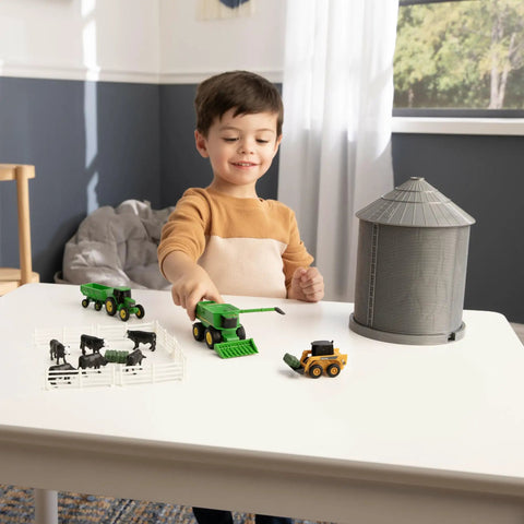 Child playing with 1 64 Scale Farm Playset With Grain Bin Includes Tractor Toys Skid Steer Farm Animal Figures And Fencing