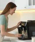 Barista-Grade Stainless Steel Espresso Shot Cup With Handle, V-Shaped Spouts Measuring Cup in use with coffee machine.