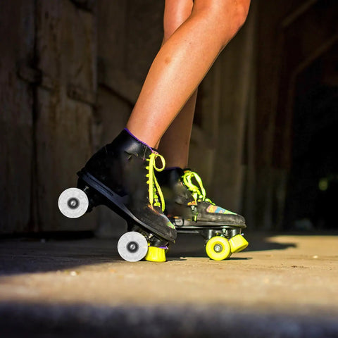 Side view of black quad skates with 4 piece luminous PU roller skate wheels set with LED light for outdoor use.