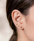 Five Piece Gold Ball Stud Earrings Set For Women Including 3mm 4mm 5mm 6mm And 7mm Sizes, 14K Gold Plated With 316L Steel Pins, Super Versatile Everyday Earrings. Three gold ball studs on ear