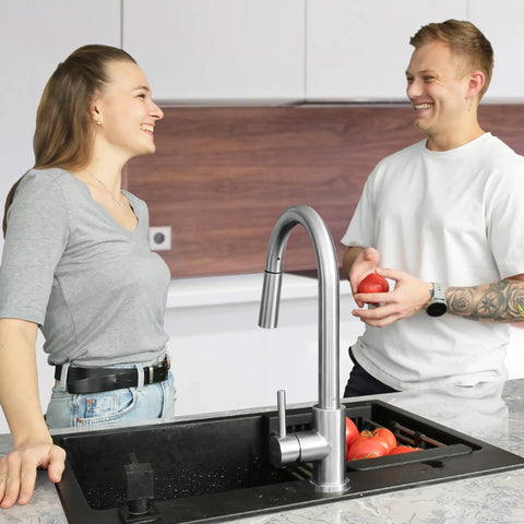Pull Down Kitchen Faucet With Brushed Nickel Finish shown with couple in modern kitchen setting