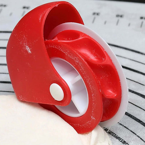 Close-up of red pastry wheel cutter with white inner wheel for pie crust decoration
