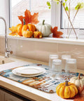 Fall Thanksgiving Dish Drying Mat Set 2 Pack Must Have With Pumpkin And Autumn Leaves Wood Grain Design on counter with dishes