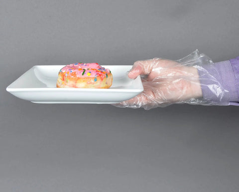 Hand wearing Clear Embossed Poly Gloves Large Ambidextrous For Food Handling holding donut plate