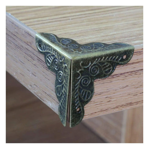 Antique Brass Corner Protectors For Wooden Boxes And Jewelry Cases Vintage Triangle Edge Guards With Screws on wooden surface.