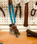 Foldable Small Hinges for Exterior Doors on workbench with tools, showcasing iron door springs and sturdy design in workshop setting.