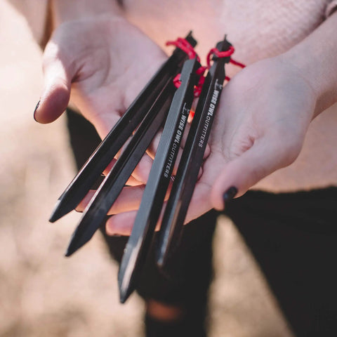 Close-up of hands holding Beefy 16 Pack 7075 Aluminum Tent Stakes 7.25 Inch Long Heavy Duty Ground Pegs Rust Resistant For Camping Canopy