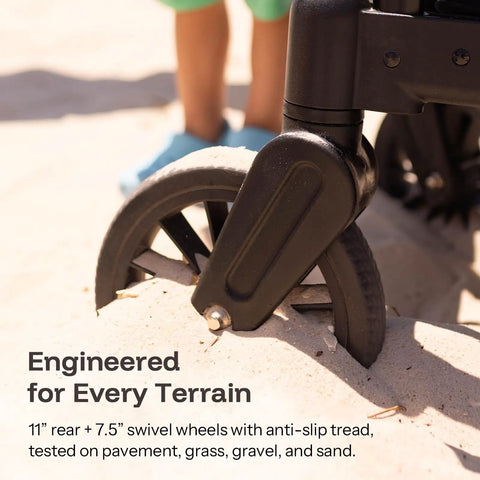 Close-up of All-Terrain Wagon Stroller For Two Kids wheel on sand showcasing 11-inch rear and 7.5-inch front swivel wheels