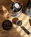 Rock Solid Espresso Knock Box With Top Shelf Removable Bar showing wood-handled portafilter and coffee grounds.