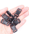 Hand holding several 100 Pack Three Eighths Inch Curved Contoured Plastic Quick Side Release Buckles For Paracord Bracelets Dog Collars Masks And DIY Straps Durable POM Buckle Clips For Easy Clasp And Replacement in black.